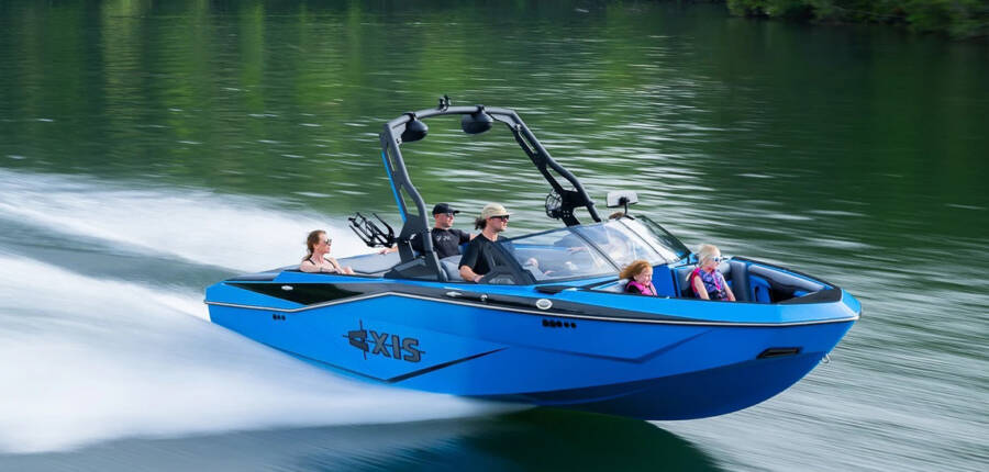 Axis boat driving fast on the watr with kids and family enjoying the water