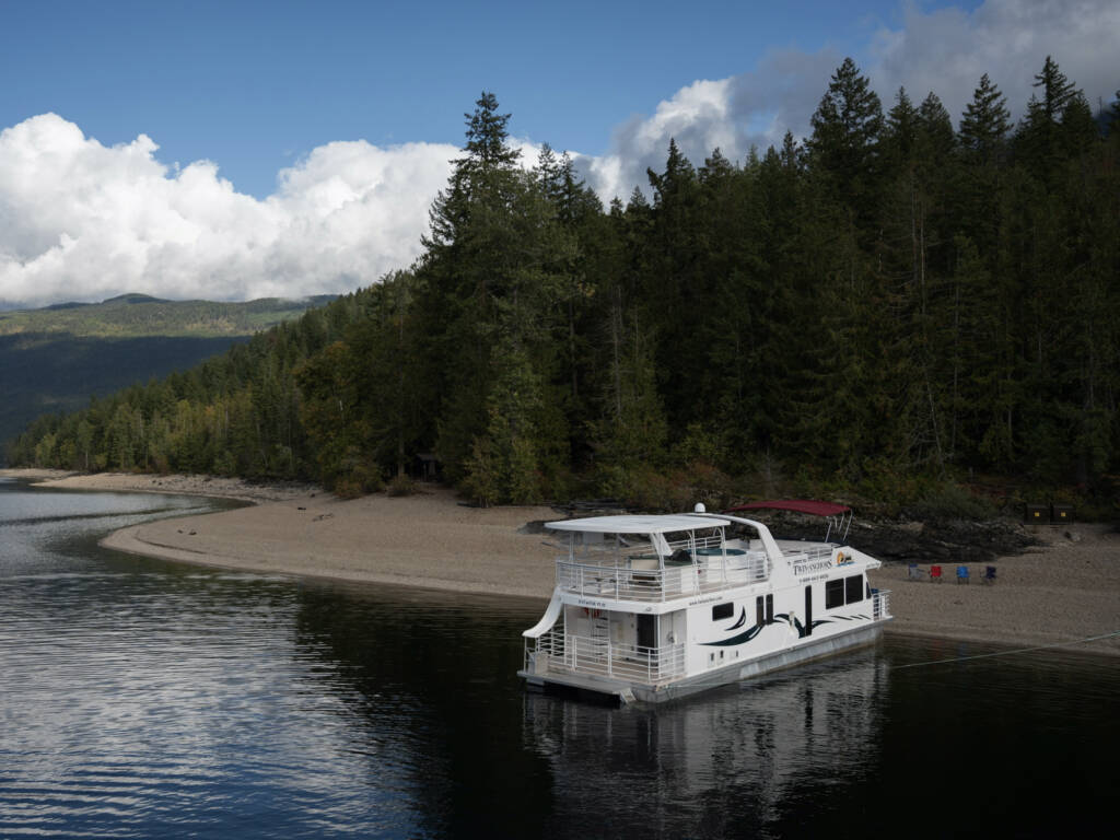 The Opal luxury houseboat anchored at a sandy cove on Bullards Bar Reservoir
